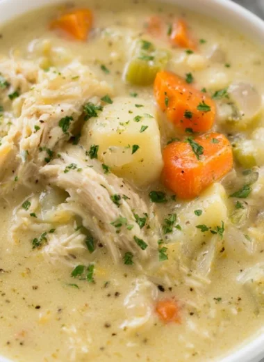 Bowl of healthy chicken pot pie soup garnished with vegetables and herbs