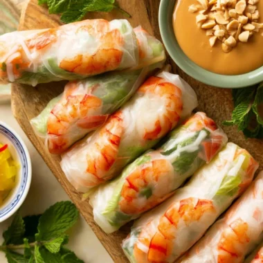 Plate of traditional Vietnamese fresh spring rolls filled with colorful vegetables and shrimp.